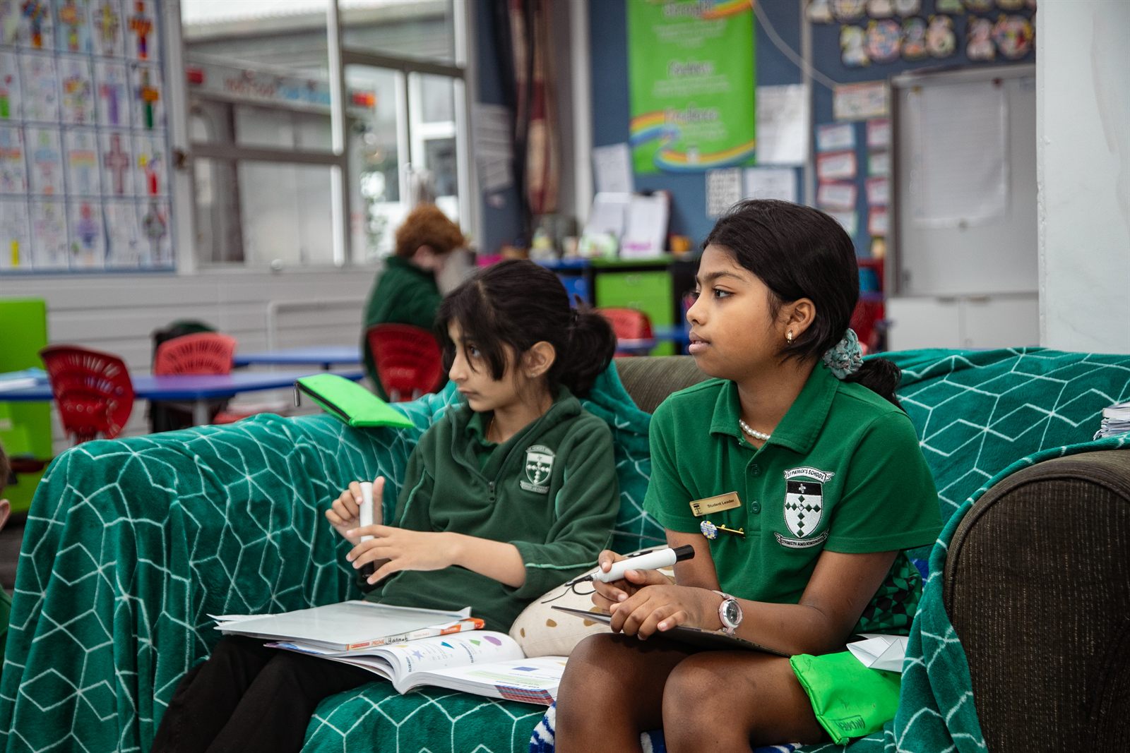 Two St Patrick's students reading together on a classroom couch