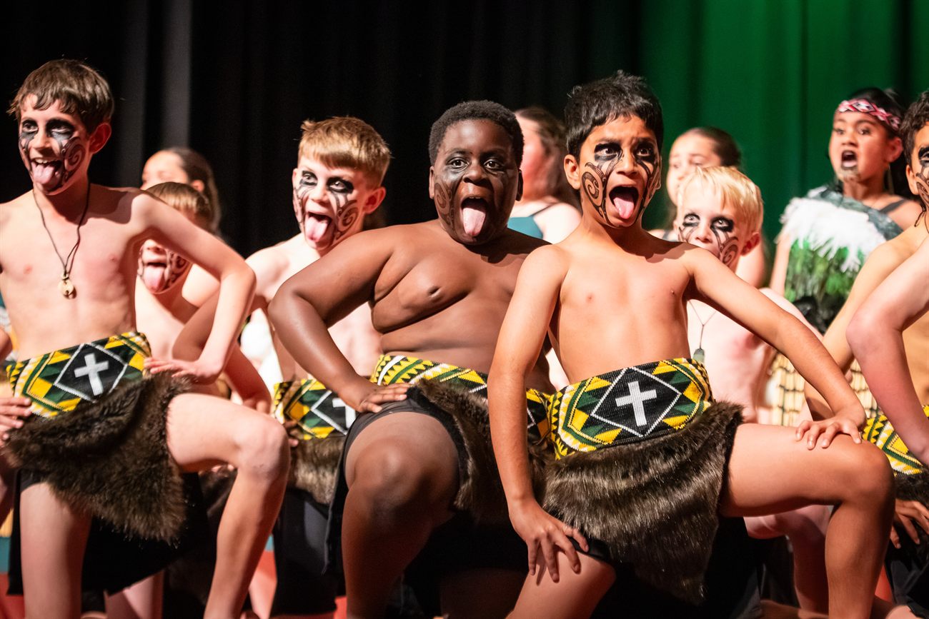 St Patrick’s boys performing a haka on stage in kapa haka costume and face paint