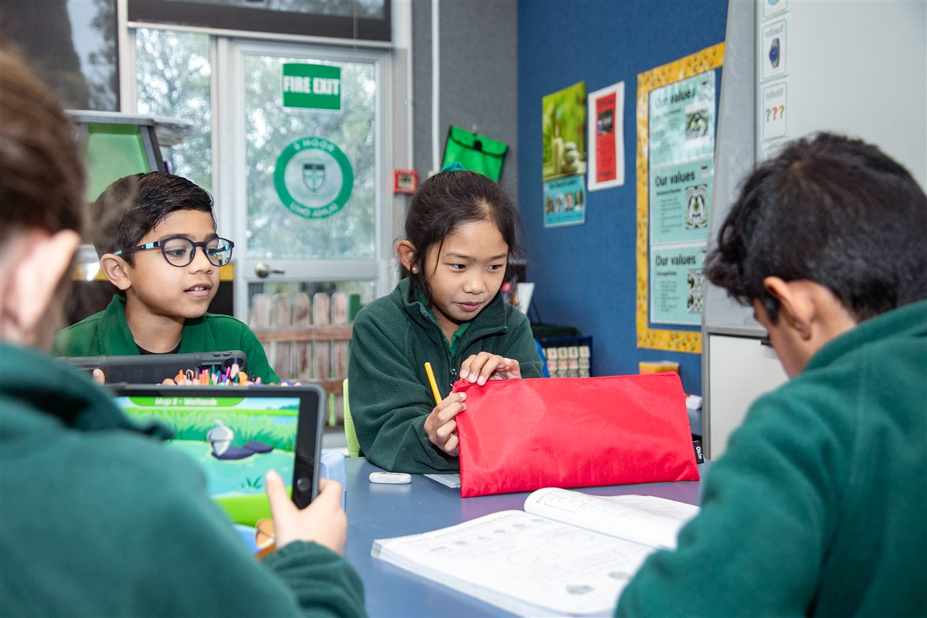 St Patrick's students working together at their desk with a tablet and workbook