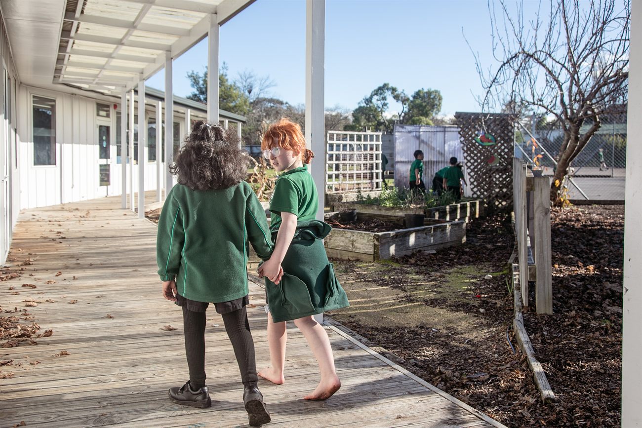 Two St Patrick's girls walking hand in hand along the school veranda