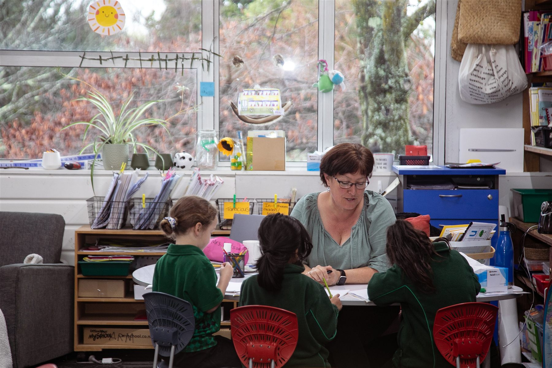 A St Patrick's teacher working with three students at a classroom table
