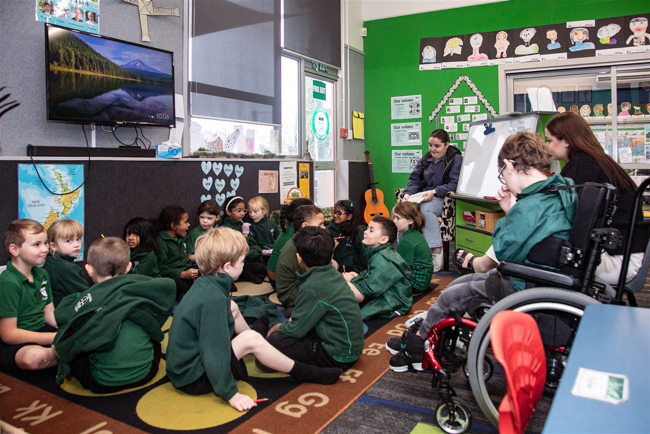 A welcoming St Patrick's class, including a student in a wheelchair, gathered together for mat time