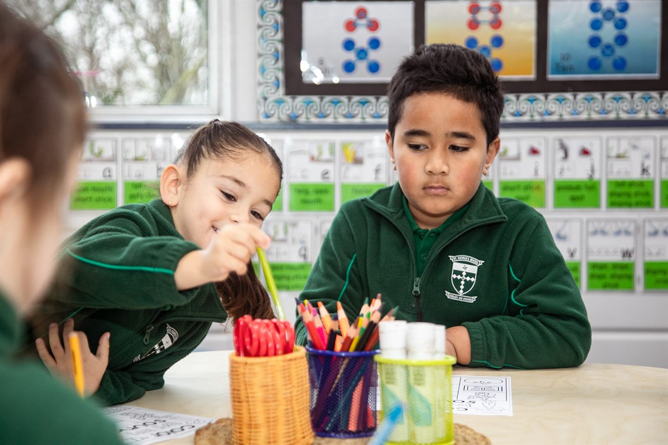 Two young St Patrick's students working side by side at their classroom desk