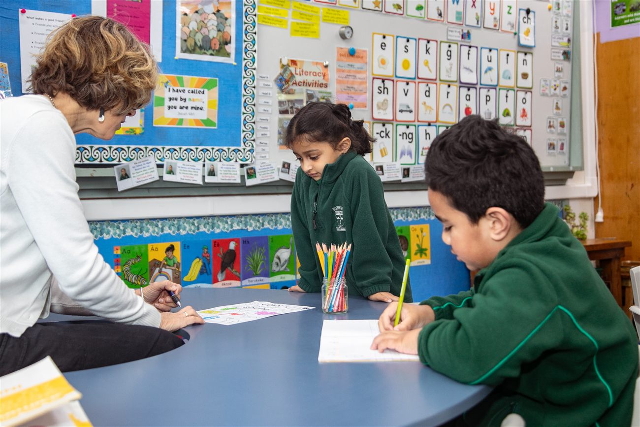 A St Patrick's kaiako working one-to-one with a student at a classroom table