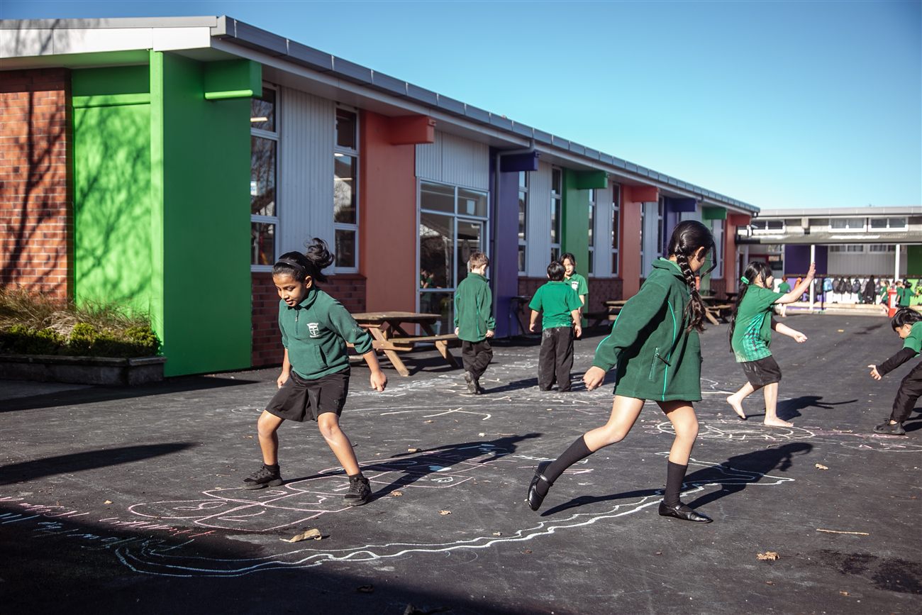 A St Patrick's student running across a chalk-covered playground