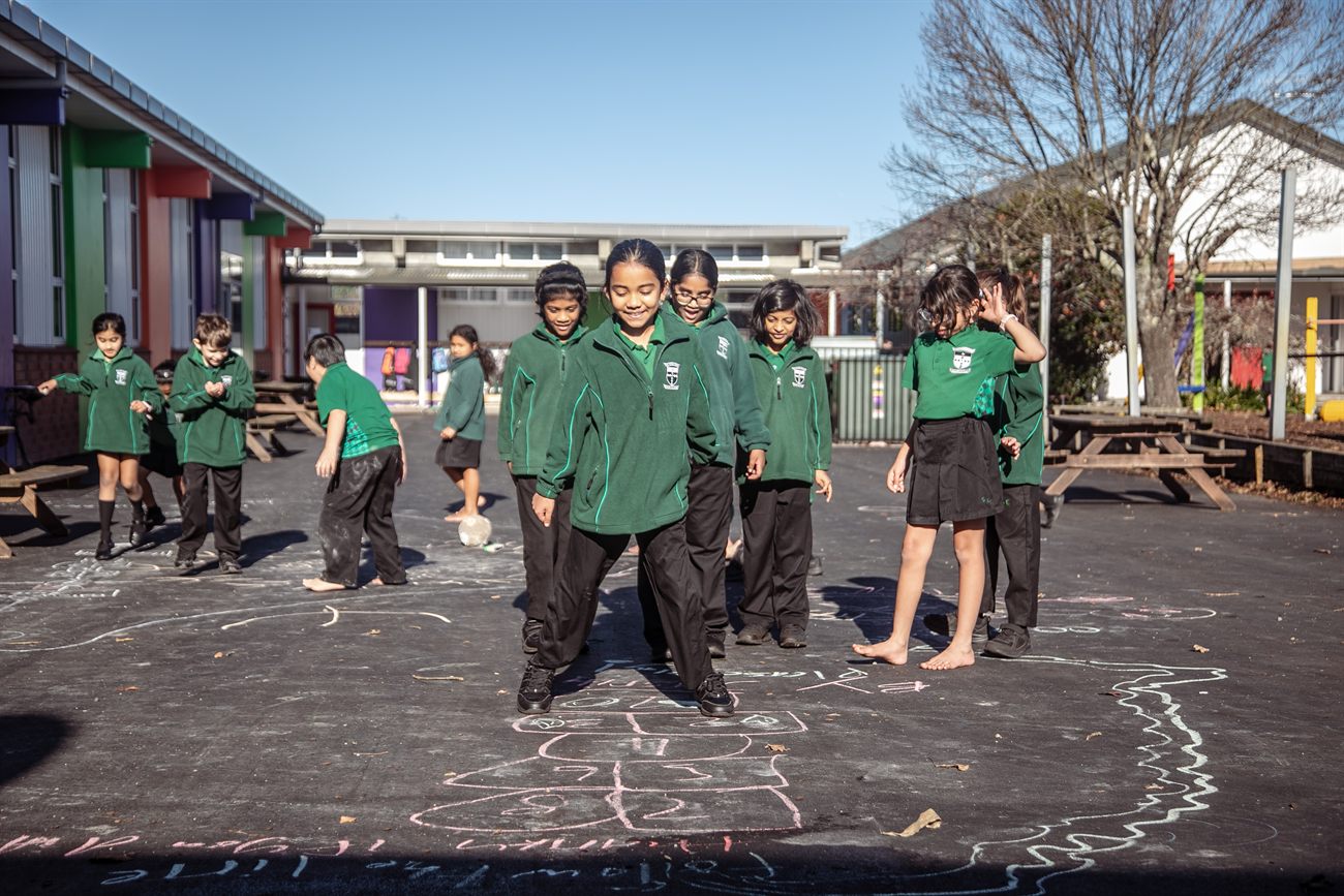 A mixed group of St Patrick's students smiling together in the sunny school courtyard